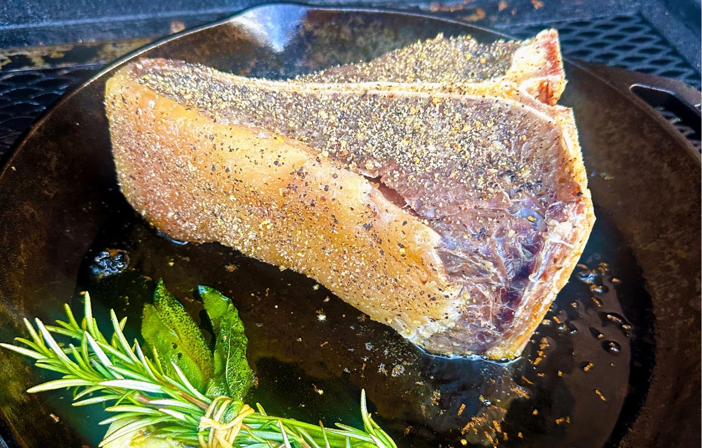 Steak searing with herbs in cast iron